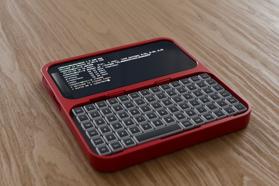 A flat red one-piece slate on a wooden table, holding an iPhone above a compact keyboard.